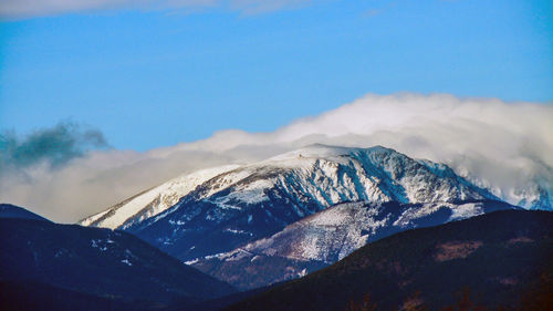 Scenic view of snowcapped mountains against blue sky