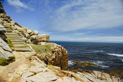 Rock formation on beach against sky