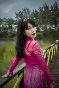 Portrait of girl standing against pink trees