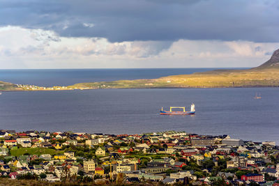 High angle view of town by sea against sky