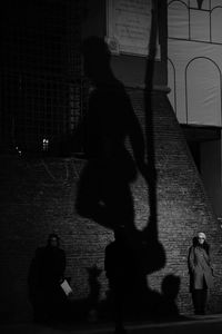 Shadow of people walking on street at night