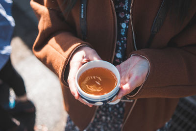 Midsection of man holding coffee cup