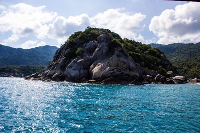 Rock formation in sea against sky