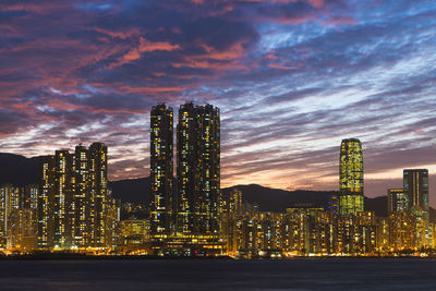 Illuminated buildings against sky at night