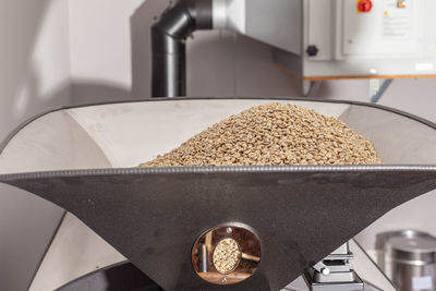 Green beans in the funnel of a coffee roasting machine