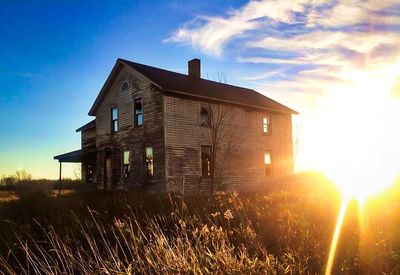 Low angle view of sun shining through house window