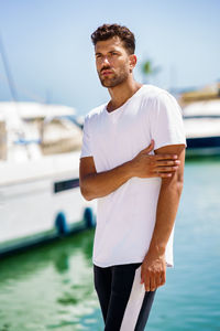 Young man standing at harbor