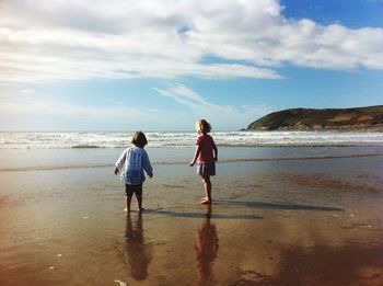 Full length of two children standing on beach