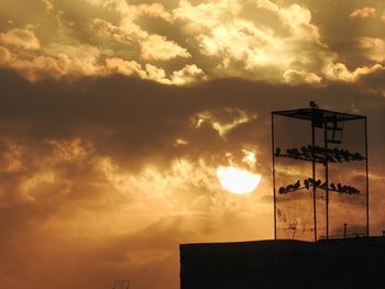 Low angle view of silhouette building against sky during sunset