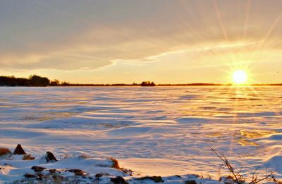 Scenic view of frozen lake against sky during sunset