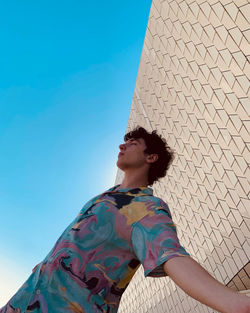 Low angle view of young man against clear sky