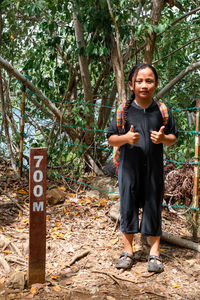 Portrait of girl standing against tree