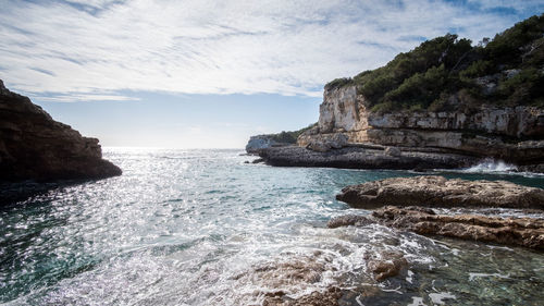 Rock formation in sea against sky