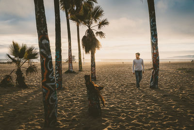 Man standing at beach against sky