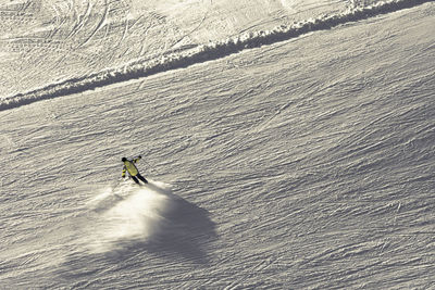 High angle view of people skiing on snow covered landscape