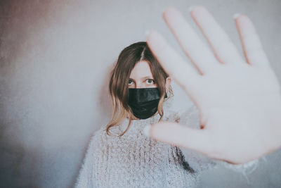 Portrait of woman with hand on wall