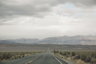 Road by landscape against sky