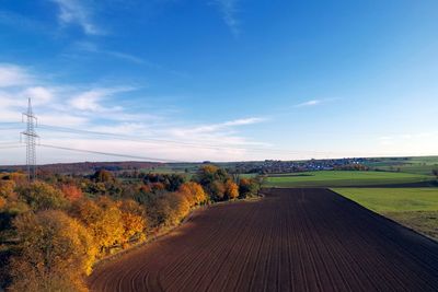 Road amidst field against sky