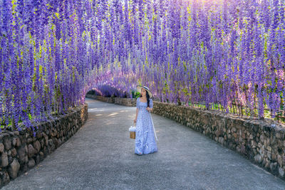 Rear view of woman standing on footpath