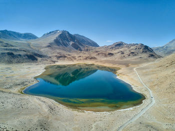 Scenic view of lake and mountains against blue sky