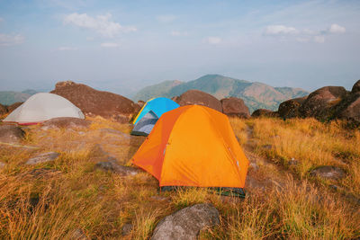 Tent on field by mountain against sky