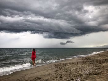 Red woman and the tempest at seaside