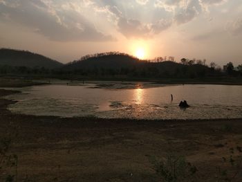 Scenic view of lake against sky during sunset