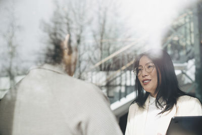 Smiling businesswoman discussing with coworker in office