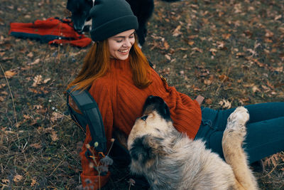 Full length of woman with dog on field