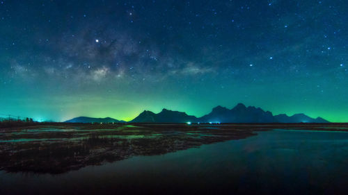 Scenic view of lake against sky at night