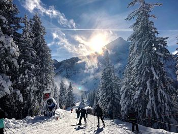 People on snow covered mountain against sky