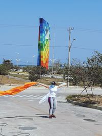 Rear view of man walking on road against sky