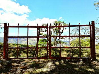 Fence and trees against sky