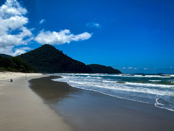 Scenic view of beach against blue sky