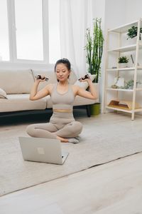 Portrait of woman sitting on floor at home