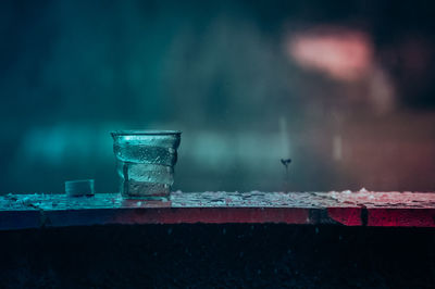 Close-up of drinking glass on wet table during monsoon