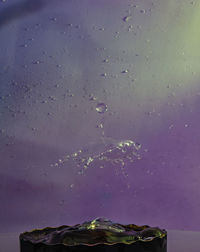 Close-up of water splashing against sky during winter