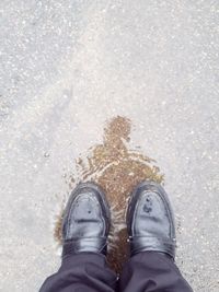 Low section of man standing on wet street