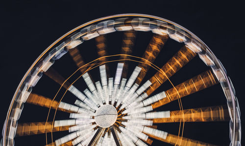 Low angle view of built structure at night and ferris wheel