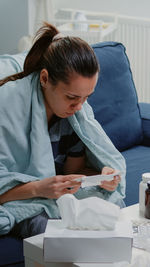 Mother and female doctor examining patient at home