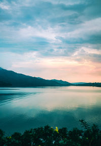 Scenic view of lake against sky at sunset