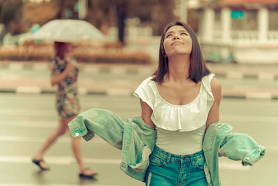 Woman standing on road in city