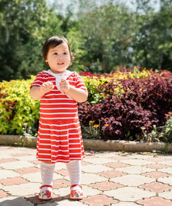Portrait of girl standing against red wall