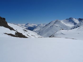 Scenic view of snowcapped mountains against clear blue sky