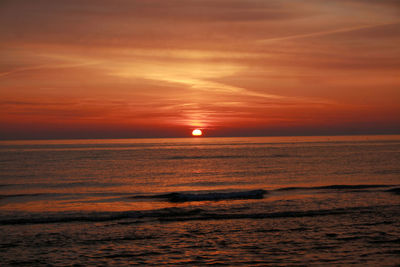 Scenic view of sea against orange sky