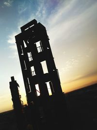 Low angle view of silhouette building against sky at sunset