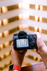 Cropped hands of man photographing from camera