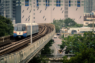 Train on railroad tracks amidst buildings in city