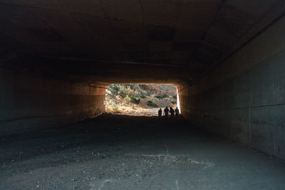 Silhouette people walking in tunnel