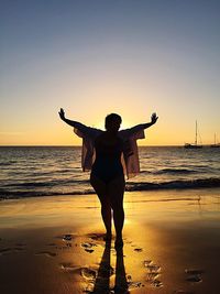 Full length of woman at beach during sunset